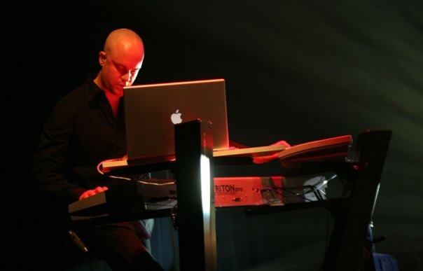 DJ Ken Johnston at an event behind a computer and other music equipment.