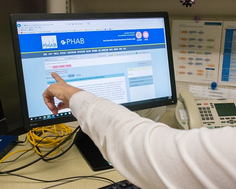 Person pointing at computer screen.